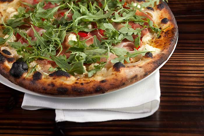 Pizza with prosciutto, burrata, and arugula